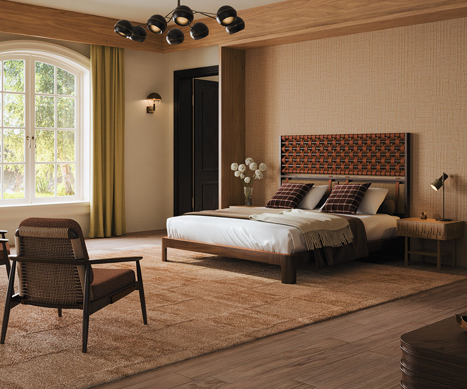 Adam armchair upholstered in Melbu 11093.52 fabric by Nobilis, featuring square webbing and genuine leather. The space also includes an O'Connell II Bed with a headboard featuring leather details in Prestige fabric from Élitis, set in a bedroom with Élitis Abaca wallpaper, a rug by Kelly Wearstler, Ralph Lauren Wallace throw pillows, a Fleming suspension lamp, and a Faraday wall lamp.