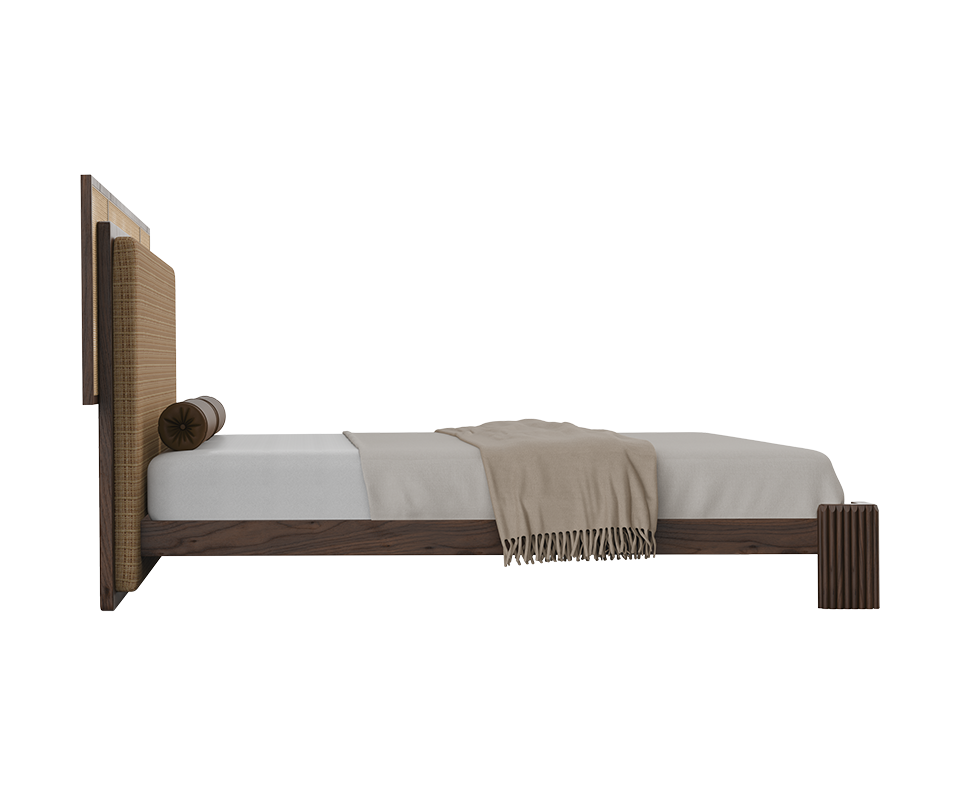 Forbes bed side view featuring a fabric and rattan headboard, cylindrical leather bolster pillows, and a walnut wood frame.
