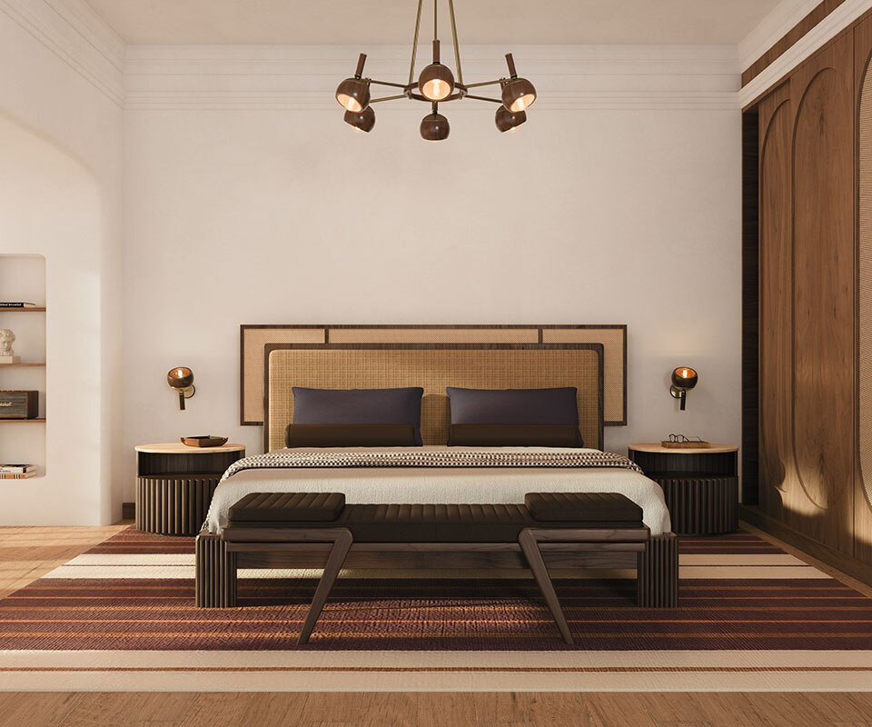 Warm-toned bedroom featuring the Forbes bed with its fabric and rattan headboard, placed between two Herbert bedside tables in smoked walnut wood. Above each bedside table, an Essen wall lamp provides soft, symmetrical ambient lighting. A Milton bench rests at the foot of the bed, while an Essen suspension lamp hangs overhead, enhancing the room’s warm, refined, and cohesive atmosphere. The space embraces the rattan bedroom furniture trend.