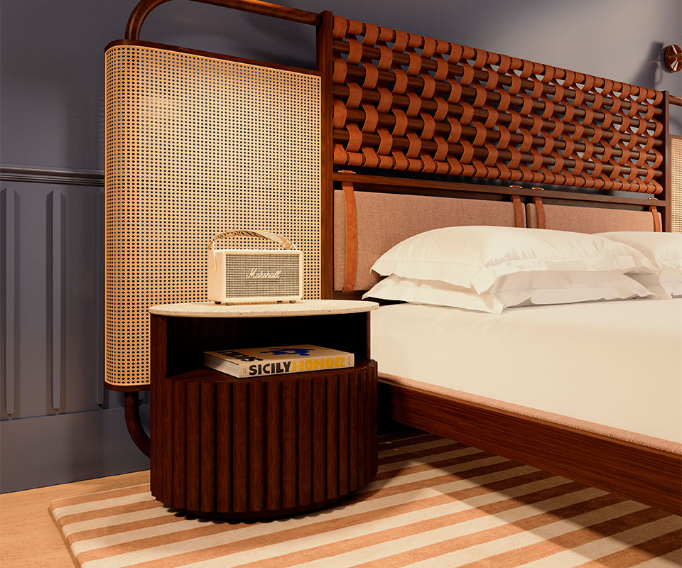 Herbert Bedside Table in a bedroom with blue and brown tones, shown with its door closed, placed next to the O'Connel Bed with a Marshall column speaker on top.