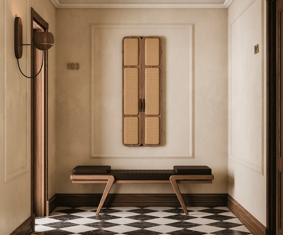 Tom folding mirror opening and closing in a hotel corridor with wooden icons, featuring upholstered doors, leather handles, and an interior mirror. The floor displays a diamond checker pattern. Below the mirror is the Milton Bench, with an oak structure and leather seat. Flaming wall lamp and Faraday wall lamp in smoked walnut wood complete the setting.